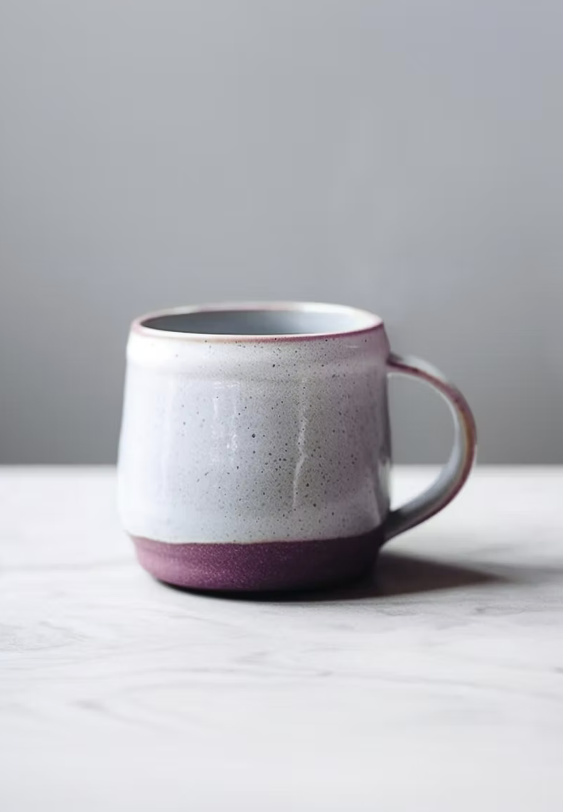 Foto: Handgetöpferte Kaffeetasse in Mauve auf Marmor – Symbolbild für den Selbstlernkurs in deinem eigenen Tempo